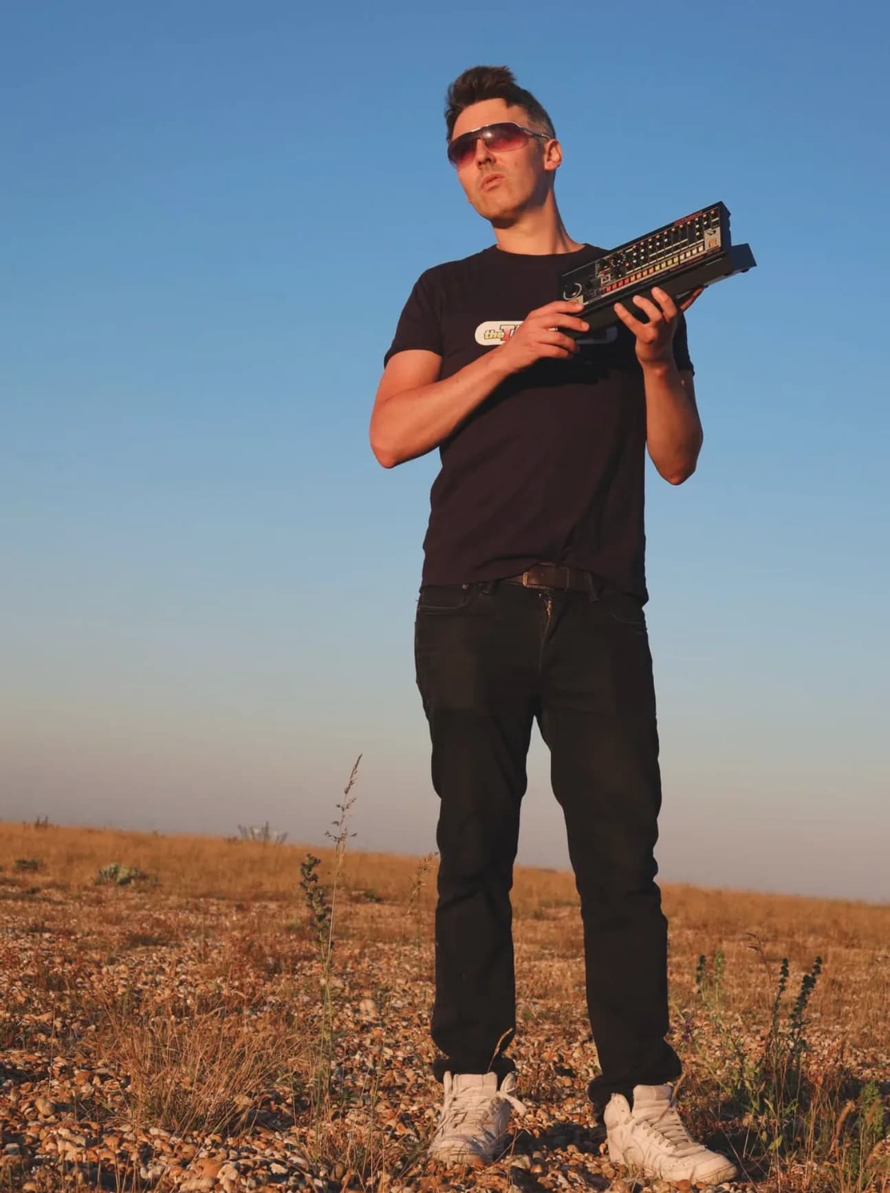 Phil in a field with a Roland TR-08 drum machine
